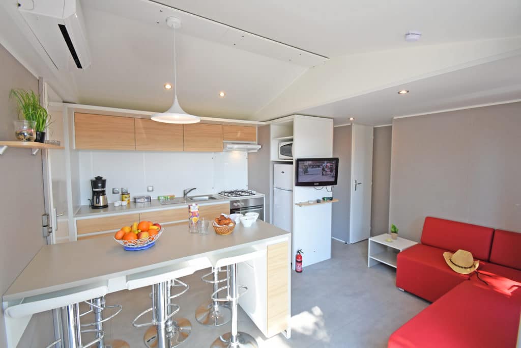 Coin cuisine et séjour équipé d’un mobil-home du camping Cap Soleil à Vias