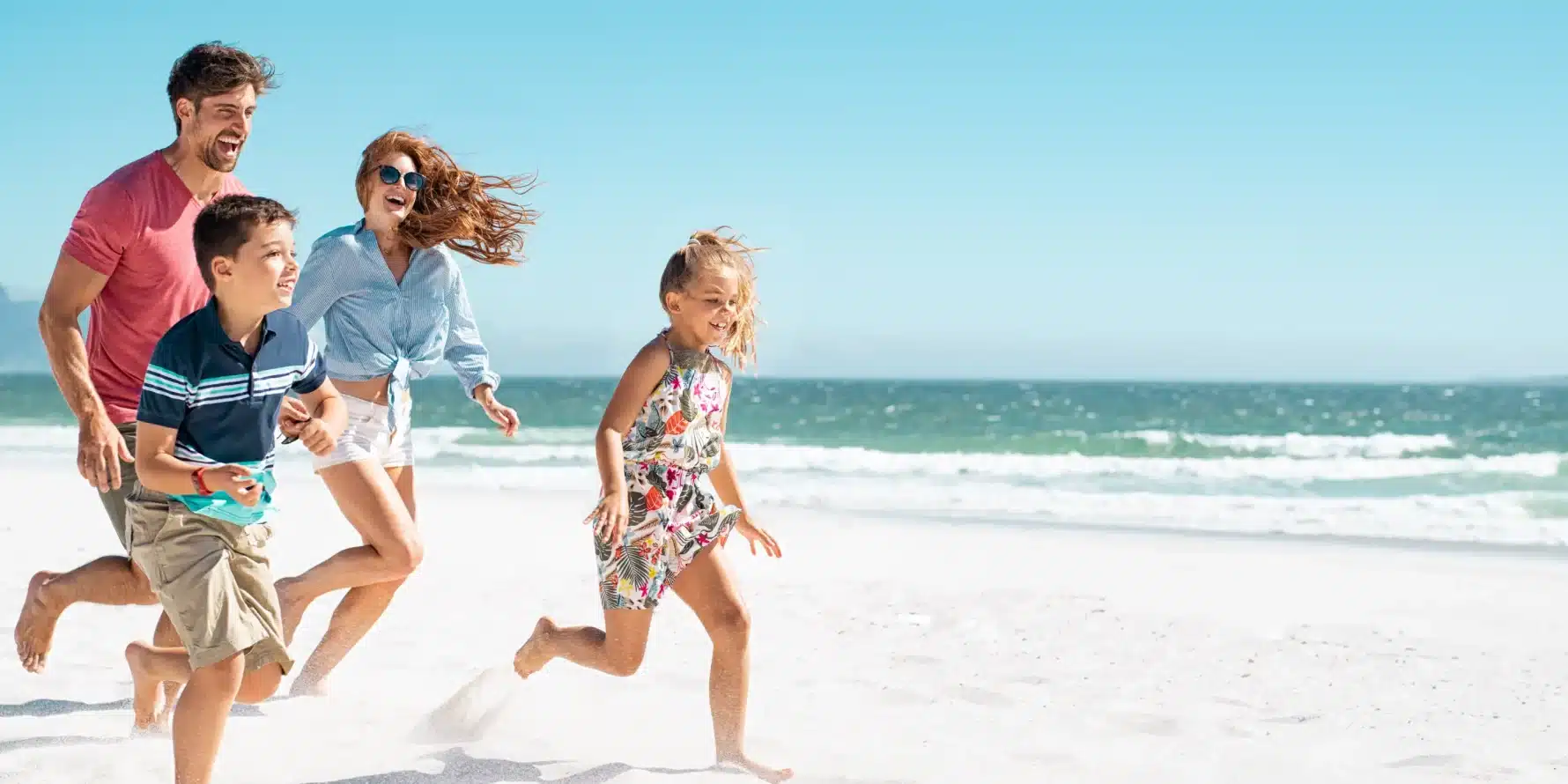 Famille courant sur la plage de sable fin du Cap d'Agde